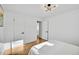 Bright bedroom featuring hardwood floors, white walls, and modern light fixture at 5211 W 4Th Ave # C, Lakewood, CO 80226