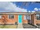 Charming brick home featuring a vibrant turquoise door with hanging basket, and manicured landscaping at 5211 W 4Th Ave # C, Lakewood, CO 80226