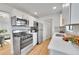 Bright kitchen with stainless steel appliances, white cabinets and countertops at 5211 W 4Th Ave # C, Lakewood, CO 80226