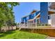 A blue home has a white patio with blue umbrella and green grass at 930 Kearney St, Denver, CO 80220