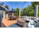 Spacious backyard deck with lounge area, dining table, and lush trees at 930 Kearney St, Denver, CO 80220