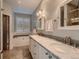 Bathroom featuring double vanity, marble countertop, soaking tub, and modern fixtures at 930 Kearney St, Denver, CO 80220