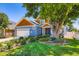 Charming home with lush landscaping, a large shade tree, and a white three car garage at 930 Kearney St, Denver, CO 80220