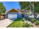 Charming two-story home showcasing a blue exterior, wood accents, a well-manicured lawn, and a two car garage at 930 Kearney St, Denver, CO 80220