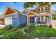 A beautifully landscaped home with a charming porch featuring a seating area and a blue door at 930 Kearney St, Denver, CO 80220