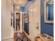 Hallway with blue walls, hardwood floors, white trim and a view into a walk in closet at 930 Kearney St, Denver, CO 80220