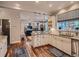 Bright kitchen featuring white cabinets, granite countertops, stainless steel appliances, and open access to the living room at 930 Kearney St, Denver, CO 80220