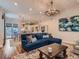 Open-concept living room with hardwood floors, a chandelier, and seamlessly connected dining area at 930 Kearney St, Denver, CO 80220