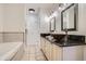 Bathroom with dual bowl sinks, a bathtub, and tan tile at 1200 Cherokee St # 206, Denver, CO 80204