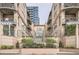 Exterior view of condos with decorative balconies, landscaped front yard, and a secure gated entrance at 1200 Cherokee St # 206, Denver, CO 80204