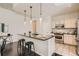 Well-lit kitchen featuring an island with bar stools, white cabinetry, and stainless steel appliances at 1200 Cherokee St # 206, Denver, CO 80204
