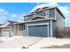 Blue two-story home with a covered front porch and a two-car garage on a partially snow-covered lot at 2165 Peralta Loop, Castle Rock, CO 80104