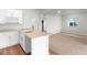 Kitchen with white cabinets, a quartz countertop, and stainless steel faucet overlooking the living area at 2165 Peralta Loop, Castle Rock, CO 80104