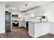 Modern kitchen with white cabinets, stainless steel appliances, and a breakfast bar at 775 S Alton Way # 2C, Denver, CO 80247