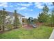 Inviting backyard featuring a playset, grassy area, and mature trees, perfect for outdoor fun at 3091 Keepsake Way, Castle Rock, CO 80109