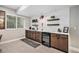 Wet bar with wooden cabinets, wine refrigerator, and stylish backsplash at 3091 Keepsake Way, Castle Rock, CO 80109