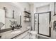Bathroom with modern sink, faucet, mirror and lighting fixture, towel rack, and glass shower with white tile at 3091 Keepsake Way, Castle Rock, CO 80109