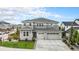Beautiful two-story home featuring gray siding, stone accents, a three-car garage, and a well-manicured front lawn at 3091 Keepsake Way, Castle Rock, CO 80109