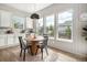 Bright breakfast nook with a round wooden table, black chairs, and lots of natural light from large windows at 3091 Keepsake Way, Castle Rock, CO 80109