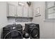 Well-organized laundry room with modern machines, stylish cabinetry, and practical design for efficient chores at 3091 Keepsake Way, Castle Rock, CO 80109