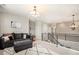 Bright loft area showcasing stairs with modern railing and comfortable seating for relaxation and entertainment at 3091 Keepsake Way, Castle Rock, CO 80109