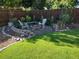Cozy backyard featuring artificial grass, a stone fire pit, and comfortable seating, ideal for outdoor relaxation at 2700 S High St, Denver, CO 80210