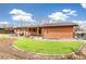 An inviting backyard with a well-maintained brick house, a covered patio, artificial grass, and stepping stone accents at 2700 S High St, Denver, CO 80210