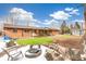 Large backyard featuring artificial turf, a brick firepit, and a shed, perfect for outdoor activities and relaxation at 2700 S High St, Denver, CO 80210