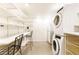 Modern laundry room featuring a stacked washer and dryer, storage shelving, and ample space at 2700 S High St, Denver, CO 80210