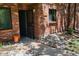 Inviting front entrance with red brick facade, screen door, and rock accents around the exterior of the home at 2261 S Buckley Rd # 102, Aurora, CO 80013
