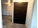 Hallway with wood flooring, large storage cabinet, and view into a room with ceiling fan at 2261 S Buckley Rd # 102, Aurora, CO 80013