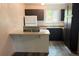 Kitchen featuring dark cabinets, laminate countertops and flooring, and natural light from window at 2261 S Buckley Rd # 102, Aurora, CO 80013