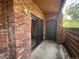 Outdoor patio area featuring brick walls, a sliding glass door, and an additional storage door at 2261 S Buckley Rd # 102, Aurora, CO 80013