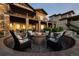 A backyard has a stone patio with a firepit and stone accents along the exterior of the two-story home at 10783 Backcountry Dr, Highlands Ranch, CO 80126