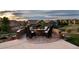 A stone patio features a built-in fire pit with chairs for outdoor gatherings in a scenic neighborhood at 10783 Backcountry Dr, Highlands Ranch, CO 80126