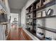 Inviting hallway featuring custom built-in shelving and wood flooring throughout at 10783 Backcountry Dr, Highlands Ranch, CO 80126