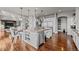 Large kitchen island with white cabinets and stainless steel appliances, seamlessly flowing into the living area at 10783 Backcountry Dr, Highlands Ranch, CO 80126