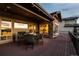 An outdoor living space is on the deck with a fire table and chairs and the sunset reflecting through the windows at 10783 Backcountry Dr, Highlands Ranch, CO 80126