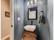 Stylish half bathroom with a modern vessel sink, dark blue walls, and a wooden vanity at 2010 Saddleback Dr, Castle Rock, CO 80104