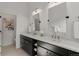 Bathroom featuring dual sinks with stylish faucets and hardware, with a modern vanity providing ample storage space at 6803 Snowshoe Trl, Evergreen, CO 80439