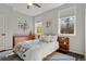 Bright bedroom featuring stylish decor, a comfortable bed, a ceiling fan, and large windows that offer an abundance of natural light at 6803 Snowshoe Trl, Evergreen, CO 80439
