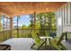 Inviting covered deck with comfortable seating and stunning views of the surrounding forest at 6803 Snowshoe Trl, Evergreen, CO 80439