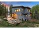 Backyard featuring a stone patio with modern seating around a fire pit, perfect for outdoor entertaining at 6803 Snowshoe Trl, Evergreen, CO 80439