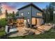 Backyard includes a hot tub, dining set, and stone patio, perfect for relaxation and outdoor dining at 6803 Snowshoe Trl, Evergreen, CO 80439