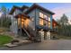 Stunning contemporary home boasts an attached two-car garage and inviting stairway to the covered porch at 6803 Snowshoe Trl, Evergreen, CO 80439
