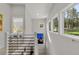 Upstairs hallway featuring a modern railing, artwork, and windows with views of the outdoors providing a light and airy space at 6803 Snowshoe Trl, Evergreen, CO 80439