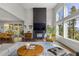 Open-concept living room features a fireplace, large windows, and seamless flow to the dining area at 6803 Snowshoe Trl, Evergreen, CO 80439