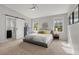 Spacious main bedroom featuring natural light from large windows, ceiling fan, and a barn door leading to the ensuite bathroom at 6803 Snowshoe Trl, Evergreen, CO 80439