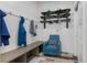Stylish mudroom with built-in bench, blue accent chair, and convenient ski storage at 6803 Snowshoe Trl, Evergreen, CO 80439
