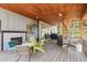 Covered patio with fireplace, BBQ, outdoor seating and wood planked ceiling at 6803 Snowshoe Trl, Evergreen, CO 80439